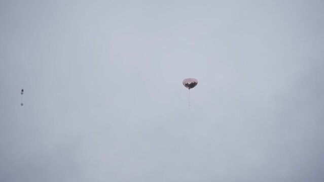 silver heart balloon flies past a house slowly into the sky in the background you can see more balloons