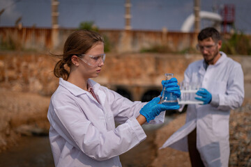 Scientist analysis professional wearing glasses and safety glove under working analysis water quality by get waste water to check water case in laboratory is environment pollution problem.