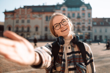 Fototapeta premium Young beautiful woman smiling happy walking on city streets on a sunny day of spring taking a selfie photo using smartphone. 
