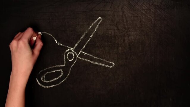Hands drawing scissors and a word tax with chalk on a blackboard in timelapse. Tax optimization concept. Drawing symbolizing tax management to increase profits