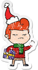 distressed sticker cartoon of a cool guy with fashion hair cut wearing santa hat