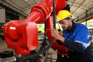 Professional heavy industry technician engineer in safety workwear and businessman maintenance and check part of robot arm machine with tablet in factory automotive. Industrial and technology concept