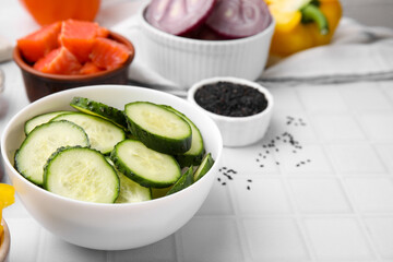 Ingredients for poke bowl on white checkered table, closeup. Space for text