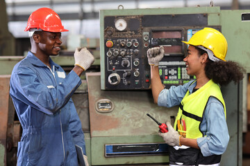 Happy smiling teamwork technician engineer or worker in protective uniform with hardhat doing fist...