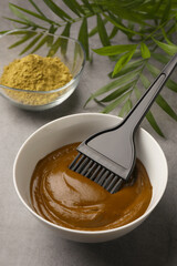 Henna cream with brush and powder on light grey table. Natural hair coloring