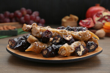 Many delicious sweet churchkhelas on wooden table, closeup