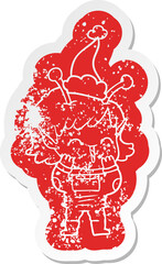 cartoon distressed sticker of a alien girl giggling wearing santa hat
