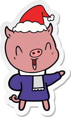 happy sticker cartoon of a pig in winter clothes wearing santa hat