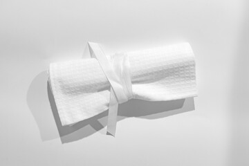 White textured cotton fabrics swatches on light background.Textile Mockup. Towel with ribbon