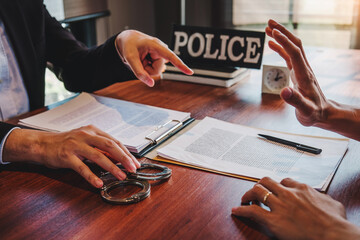 Law enforcement officer interrogating Criminals male with handcuffs in the investigation room...