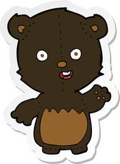 sticker of a cartoon waving black bear cub