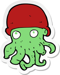 sticker of a cartoon alien head wearing hat