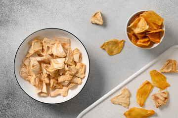 Organic dried Soursop and Jackfruit chips in white plate on gray background. Fruits chips sugar free with antioxidant, vitamin from Sri Lanka. Top view.