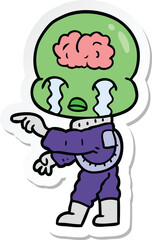 sticker of a cartoon big brain alien crying and pointing