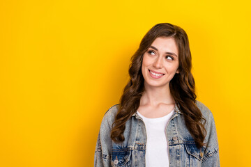Fototapeta premium Portrait of cheerful adorable minded girl beaming smile look empty space isolated on yellow color background