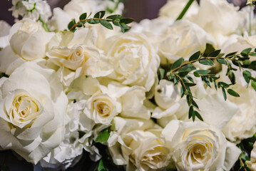 Delicate white roses flowers. Composition with copy space. Soft blurred flowers with soft bokeh in pastel tone for background. Closeup decor. Banner. Detail of decor in the interior on table.