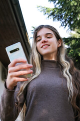 A teenage girl communicates via video link from her phone.
