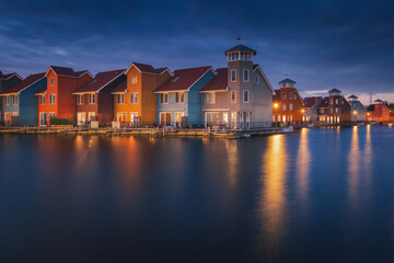 Obraz premium Colorful houses in Groningen during the blue hour. The original architecture of the houses is a frequent reason for visiting this place.