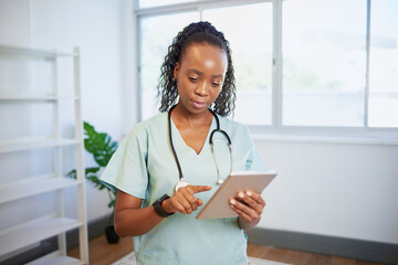 Portrait of a young Black female doctor, using digital tablet, eHealth