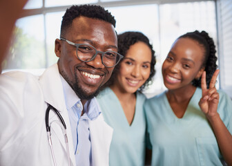 Fun selfie of three healthcare professionals stand in a row informal candid pose