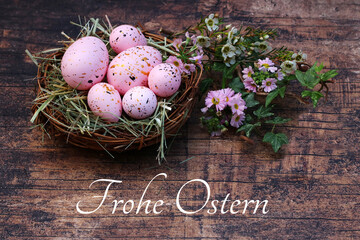 Rosa Ostereier  in einem Nest mit der Schrift Frohe Ostern.