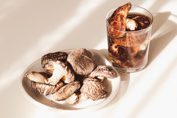 お皿に乗った干し椎茸と干し椎茸を一晩水に浸した干し椎茸の出汁が入ったグラス。