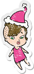 distressed sticker cartoon of a surprised girl wearing santa hat
