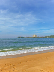 Beautiful sand beach and turquoise water. Summer holiday beach background. Ocean waves on empty tropical sand beach. Vertical background