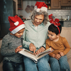 Christmas, books or reading with a grandmother and kids looking at photographs during festive...