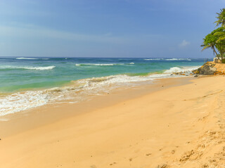 Beautiful sand beach and turquoise water. Summer holiday beach background. Ocean waves on empty tropical sand beach. Vertical background