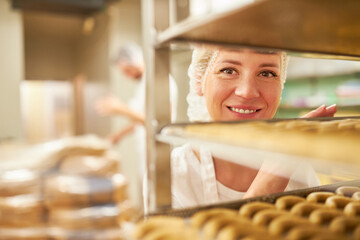 Baker apprentice in front of a shelf with vanilla crescents