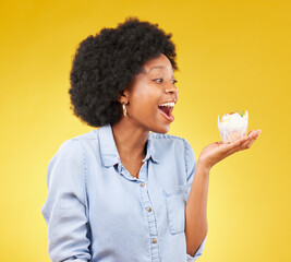 Black woman, cupcake and excited or happy in studio while eating sweet food on a yellow background....