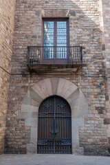 Fototapeta na wymiar Exterior Detail of a Door and Balcony in the Gothic Neighborhood, Spain