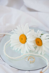 Beautiful chamomile flowers on a white tablecloth.