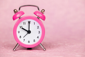 Pink retro alarm clock. Daylight savings time or happy morning background with copy space