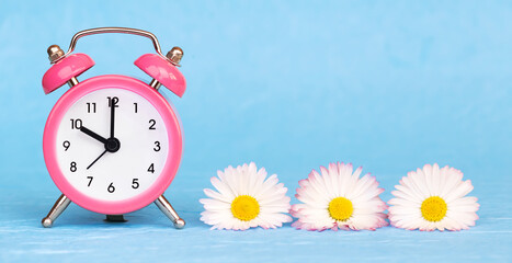 Flowers and alarm clock. Spring forward, springtime or daylight savings time banner.