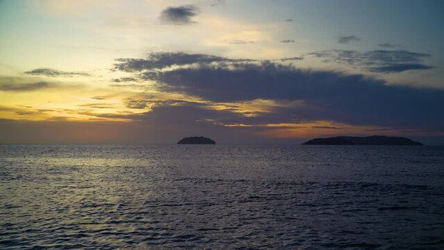 Golden Sunset Over Sea, Sunlight Reflected in Calm Water Surface, Silhouette of Islands in Background, Dramatic Sky Ocean Beach