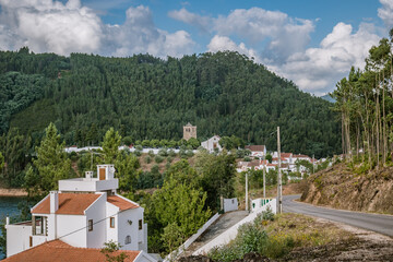 Fototapeta na wymiar Hills of forest and vegetation with road to the Dornes village in the background with Templar castle tower and buildings, PORTUGAL