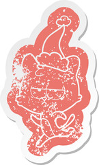 bored cartoon distressed sticker of a cat wearing santa hat