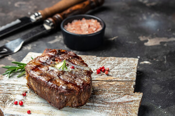 grilled steak on a wooden board. Restaurant menu, dieting, cookbook recipe top view