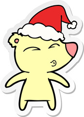 sticker cartoon of a whistling bear wearing santa hat