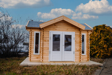 Home concepts, Miniature wooden house model with blurred green background. Selective soft focus.