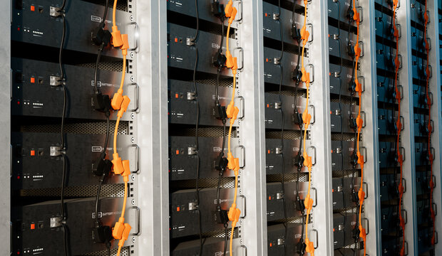 Image of a battery energy storage system consisting of several lithium battery modules placed side by side. This system is used to store renewable energy and then use it when needed. 3d rendering.