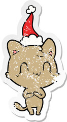 Obraz na płótnie Canvas distressed sticker cartoon of a happy cat wearing santa hat