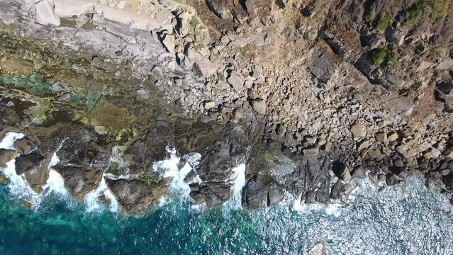 vertical aerial shot by drone of the cliffs of bejaia overlooking the mediterranean sea