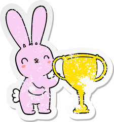 distressed sticker of a cute cartoon rabbit with sports trophy cup