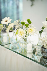 Wedding decoration table in the hall, floral arrangement. In the style vintage. Decorated dining table with flowers for guests and newlyweds, in white color.