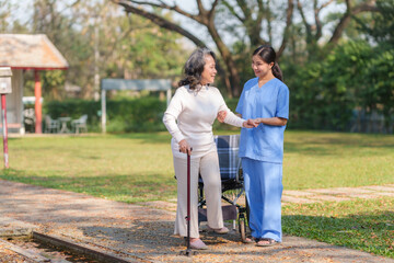 Fototapeta premium Beautiful Asian nurse taking patient walk in physiotherapy park for exercise and relaxation