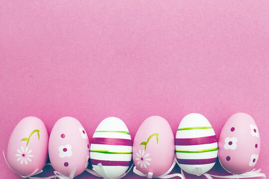 easter colorful handmade painted eggs on pink background with copy space