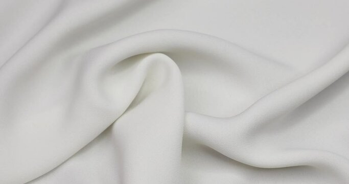 White fabric background. White cloth waves background texture. White fabric cloth textile material.